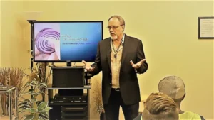 Man giving presentation to seated audience.